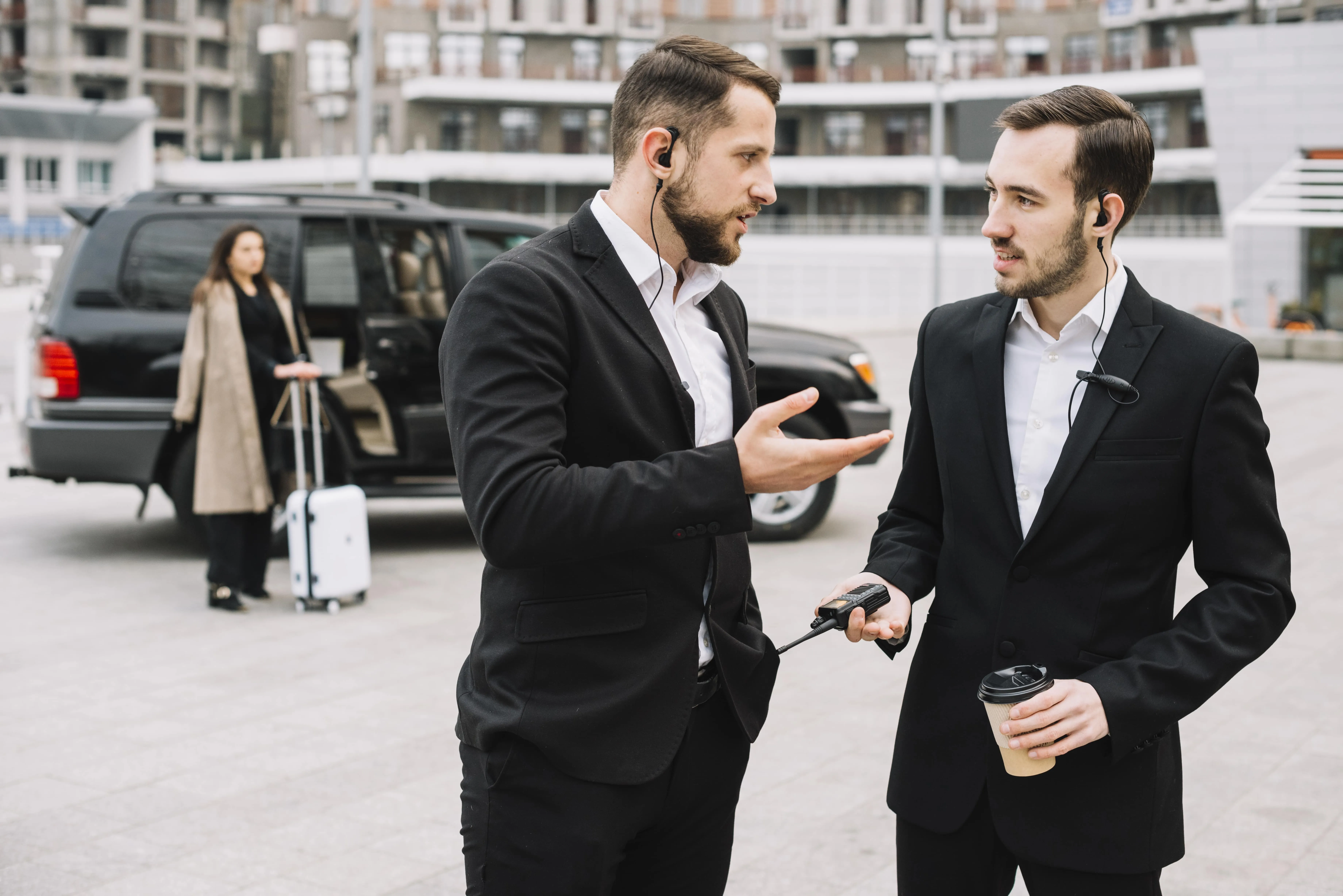 Two staff having conversation outdoors while client is waiting
